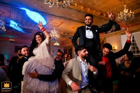 A wedding couple celebrates, lifted in the air at their Fort Garry Hotel reception.